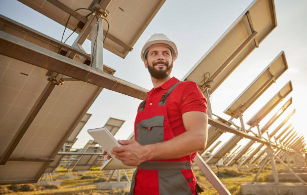 Engineer working in field with solar batteries stock photo