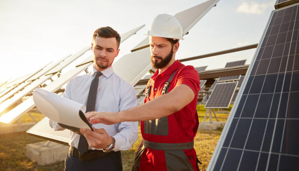 istock Contractor and manager working in field with solar panels 1393223715