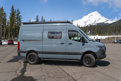 Camper van parked with gorgeous view of snowy Mt. Hood in Oregon, USA on a sunny Spring day.