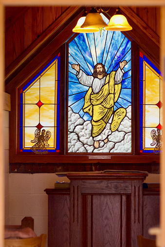 South Newport, Georgia, USA - April 1, 2018: View of stained glass artwork seen through the open door of Christ’s Chapel in Memory Park, known as “The Smallest Church in America”.