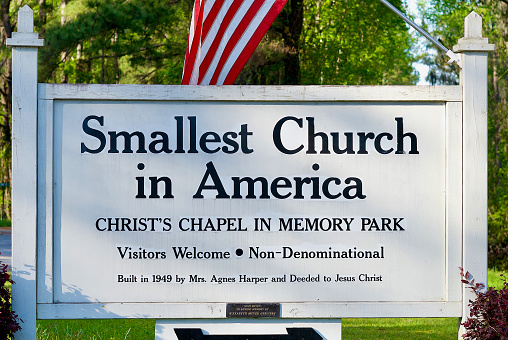South Newport, Georgia, USA - April 1, 2018: Roadside sign for Christ’s Chapel in Memory Park, known as “The Smallest Church in America”, that is open 24-hours a day to visitors.