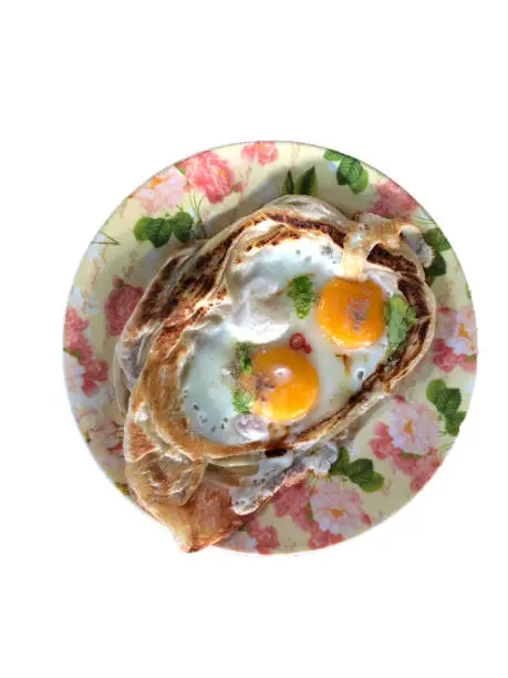 Photo of Top view of Roti Sarang Burung. it is pratha looks like bird nest with half cook eggs in the middle