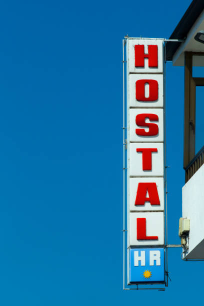 istock Hostel sign on building facade, clear sky background. 1393248215