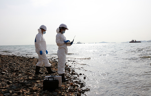 Scientist or Biologist wearing PPE protection analyze the waste water from industrial