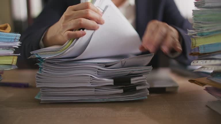 Businesswoman hands working on Stacks of documents files for finance in office