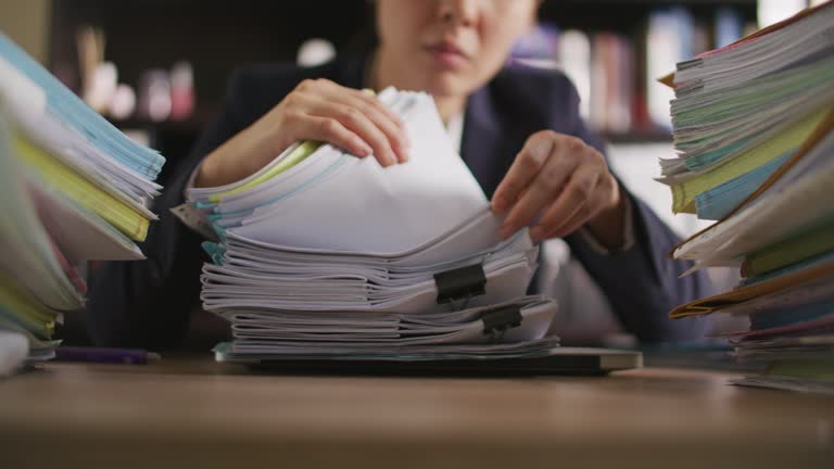 Businesswoman hands working on Stacks of documents files for finance in office