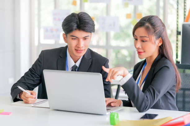 istock Two business person is sitting on working desk while brainstorming together on a computer laptop in office. 1393253690