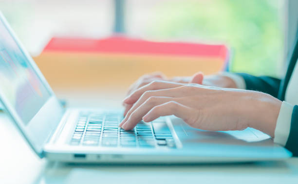 istock Businesswoman hand is writing at typing on notebook at the sametime. 1393254835