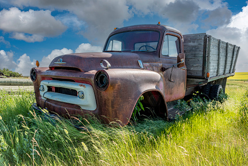 Abandoned red vintage two ton grain truck on the prairies in Saskatchewan