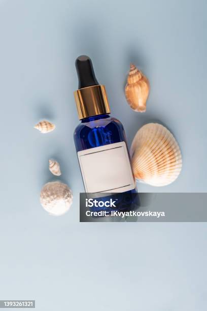 Moisturizing Face Serum On A Blue Sea Background With Seashellsthe Concept Of Cosmetics With Marine Extracts Mockap Label For Your Design Stock Photo - Download Image Now
