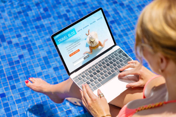 istock Woman using laptop computer with sample travel blog website on the screen, concept of travelling and blogging. 1393264561