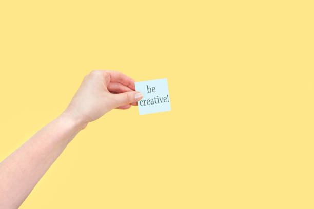 istock The hand holds a sticky note with inscription Be creative 1393266300