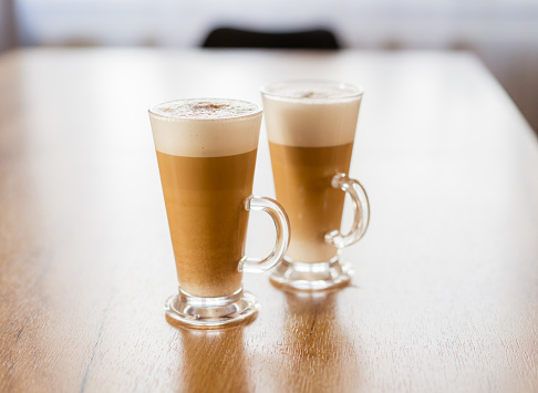 A glass of cappuccino or latte with foam in two glasses, home made coffee.