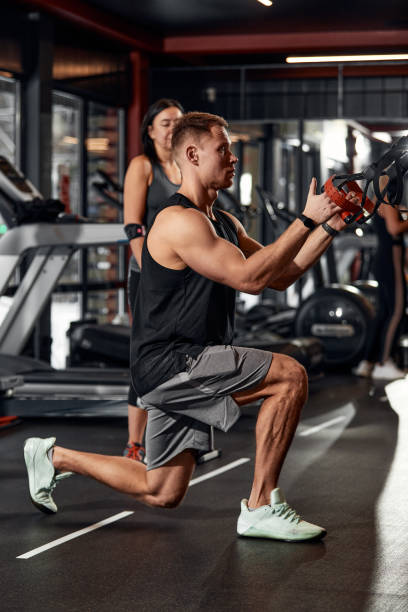 istock A man trains his arms and chest in the gym on the simulator, does exercises for different muscle groups. Fintes motivation, sports lifestyle, health, athletic body, body positive. Film grain 1393268011