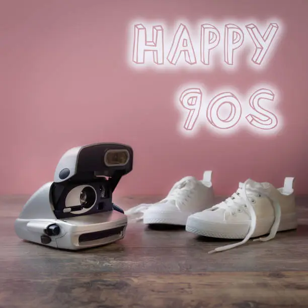 Photo of Happy 90s. Collage with classic sneakers and popular instant camera