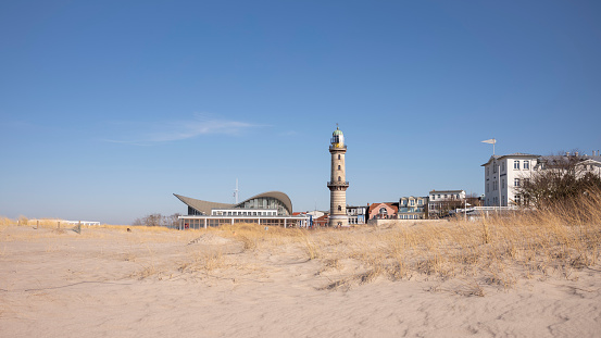 Warnemünde, Rostock, Germany - March 3, 2022: View of the lighthouse in Warnemünde Rostock over a dune near the Baltic Sea in the Baltic Sea resort.