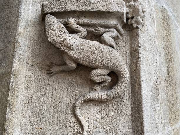 istock Small stone lizard carved into the wall of a building 1393269807