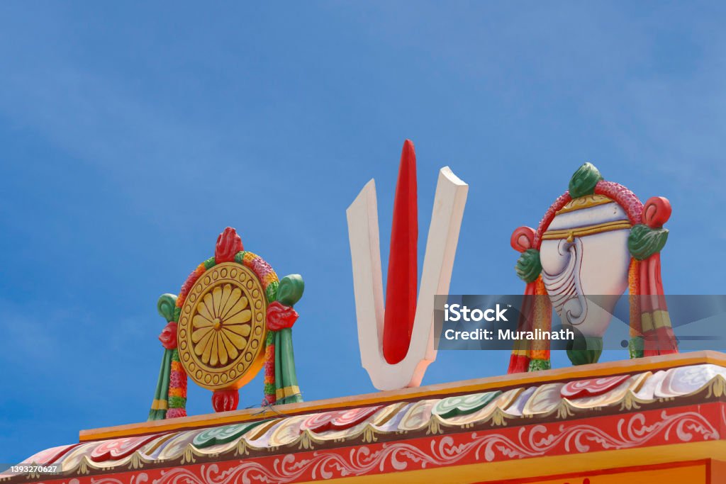 Perumal Naama statue with Shanku and Chakra on Temple tower Chakra Stock Photo