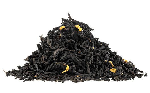 Pile of black tea with bergamot and flower petals isolated on a white background