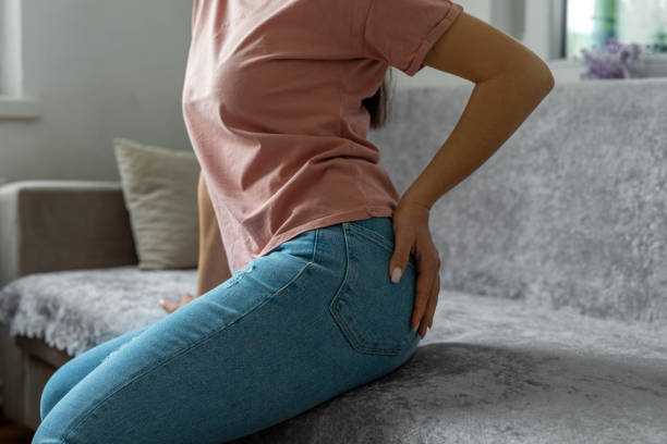 femme main tenant ses fesses parce que les hémorroïdes - cul photos et images de collection