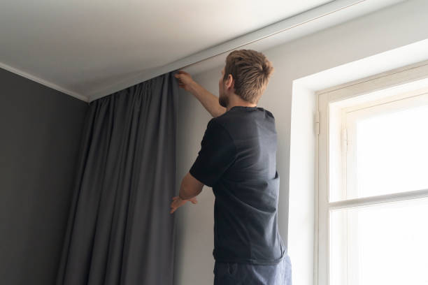 istock man doing house works, attach the railing and hang curtains at home 1393274621