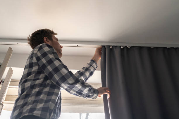istock man doing house works, attach the railing and hang curtains at home 1393274628