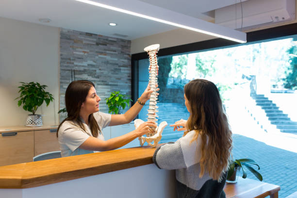 fizjoterapeuta trzymający model kręgosłupa oraz pokazujący i wyjaśniający pacjentowi przepuklinę kręgosłupa - human spine human vertebra disk spinal zdjęcia i obrazy z banku zdjęć