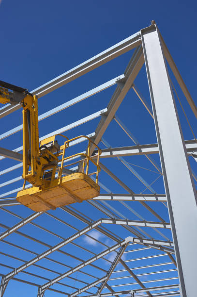 yellow lifting platform for construction in the construction of a metal structure detail of a yellow elevating platform for construction in the construction of a metal structure girder photos stock pictures, royalty-free photos & images