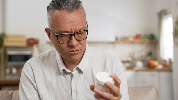 istock confused asian senior Japanese man with bad memory looking at a white container in hand and can’t remember if he has taken the pill at home. memory loss in Alzheimer’s concept 1393275849