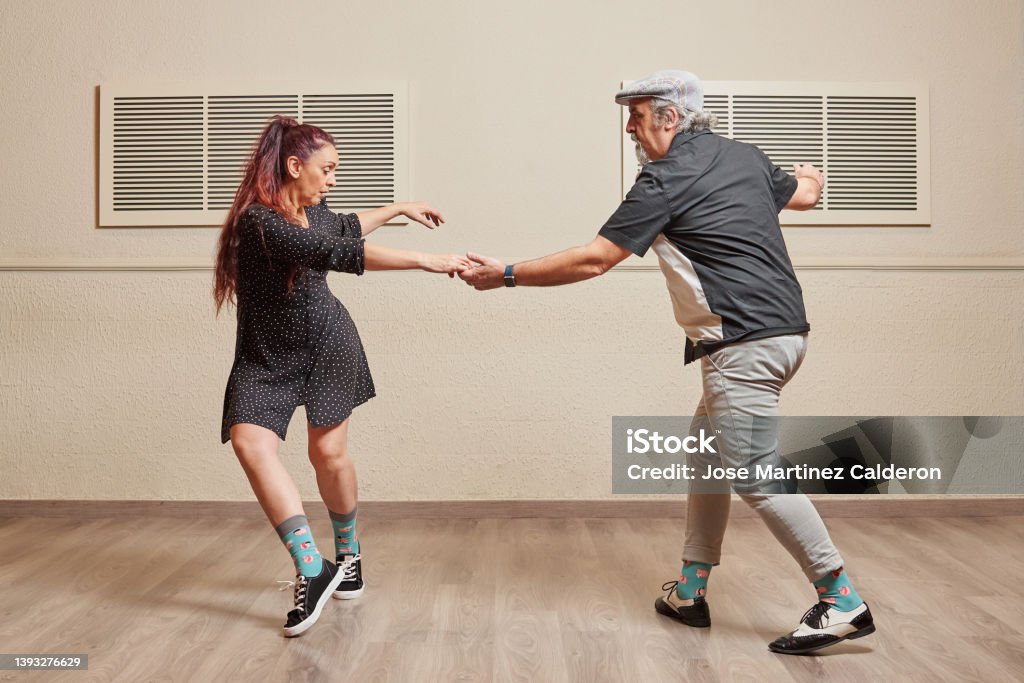 Dance couple doing a lindy hop dance move Mature couple dancing Lindy Hop in a ballroom practicing dance moves to keep fit Dancing Stock Photo
