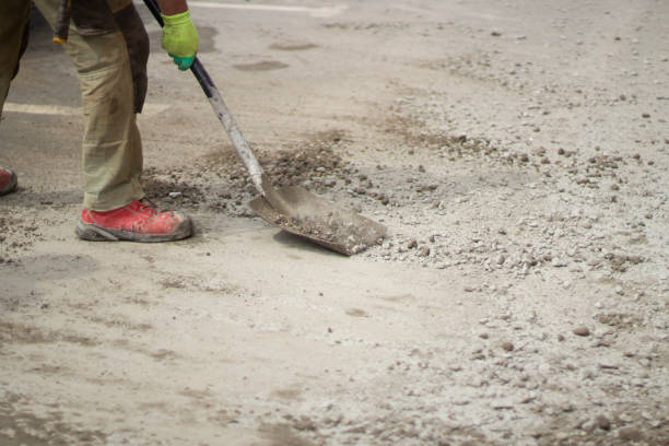 istock Work with a shovel at a construction site. A worker throws cement and gravel with a shovel. 1393276963