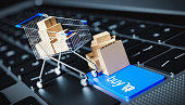 A shopping cart filled with items stands on a laptop keyboard with a buy button. internet shopping concept - 3D render