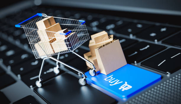 A shopping cart filled with items stands on a laptop keyboard with a buy button. internet shopping concept - 3D render A shopping cart filled with items stands on a laptop keyboard with a buy button. internet shopping concept - 3D render online business stock pictures, royalty-free photos & images