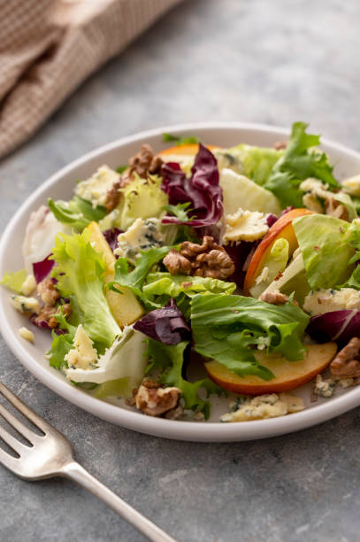 istock Salad with blue cheese, apples, arugula and nuts with spicy dressing on a grey background. Healthy eating. 1393277185