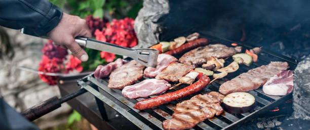 istock Man cooking meat on barbecue grill at bbq party 1393280127
