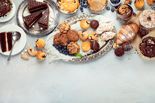 Dessert table with all kinds snacks on light background. Candy bar. Celebration concept. Top view, flat lay, copy space