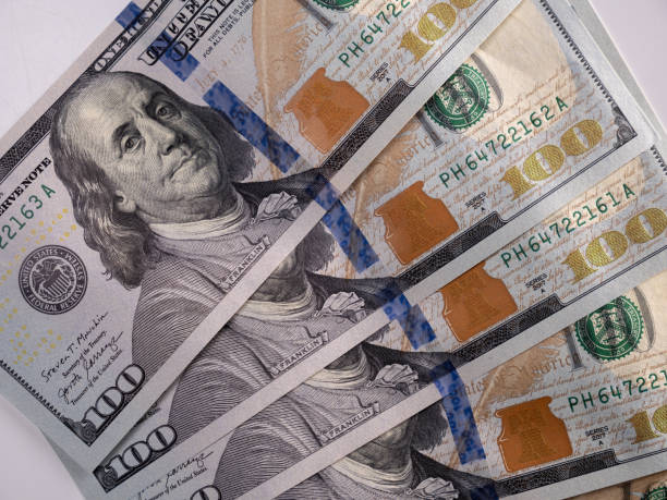 istock 100 US dollars bills lie on the table close-up 1393280623