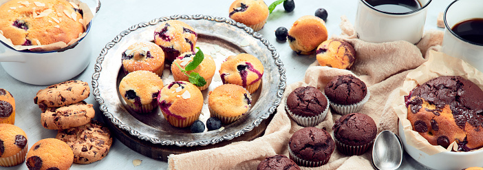 Muffins assortment on light background. Freshly baked cupcakes. Celebration concept. panorama