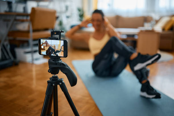 istock Close-up of personal trainer recording exercise class for her vlog at home. 1393282881