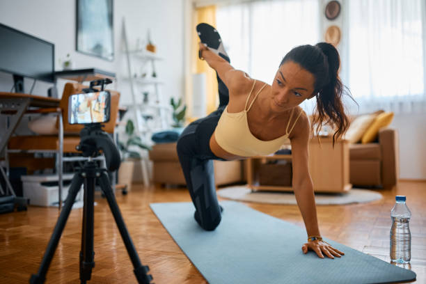 istock Fitness instructor doing stretching exercises while recording video for her vlog t home. 1393282937