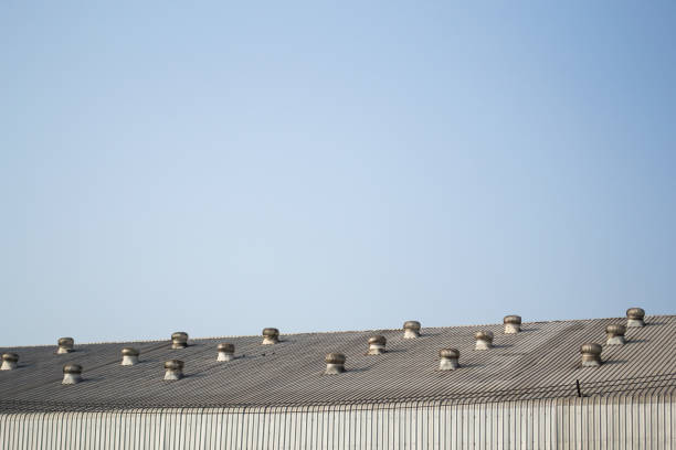 Factory metal roof with ventilator on blue sky