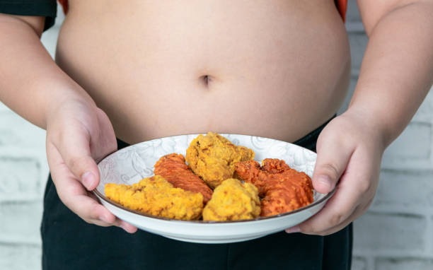 fat boy"n"n holding a plate of fried chicken - child obesity imagens e fotografias de stock