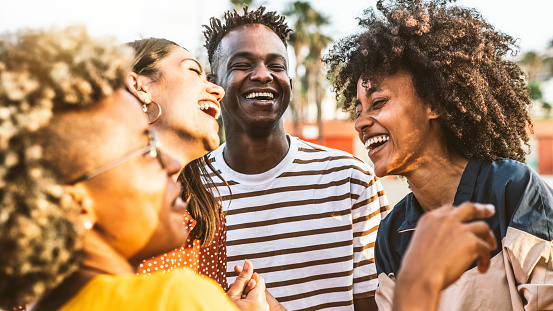 Young happy people laughing together - Multiracial friends group having fun on city street - Diverse culture students portrait celebrating outside - Friendship, community, youth, university concept