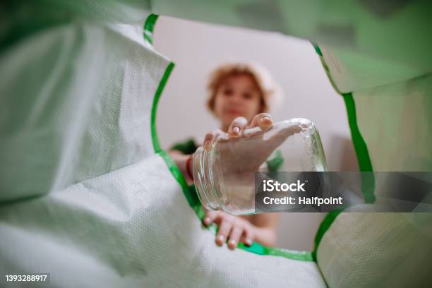 Image From Inside Green Recycling Bag Of Girl Throwing A Glass Bottle To Recycle Stock Photo - Download Image Now