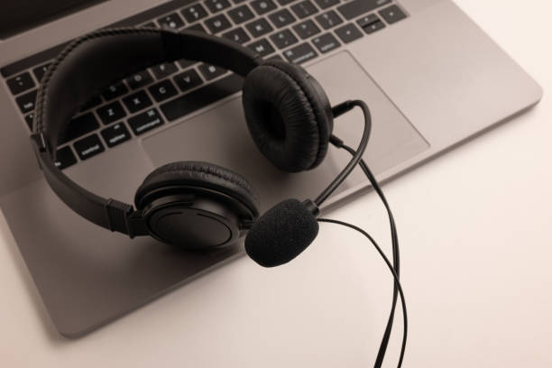 istock headset on keyboard computer laptop, call center support and customer service help, concept for communication 1393289472