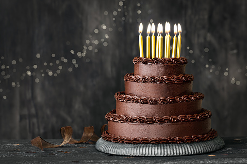 Pastel de cumpleaños de chocolate escalonado con velas de cumpleaños doradas photo