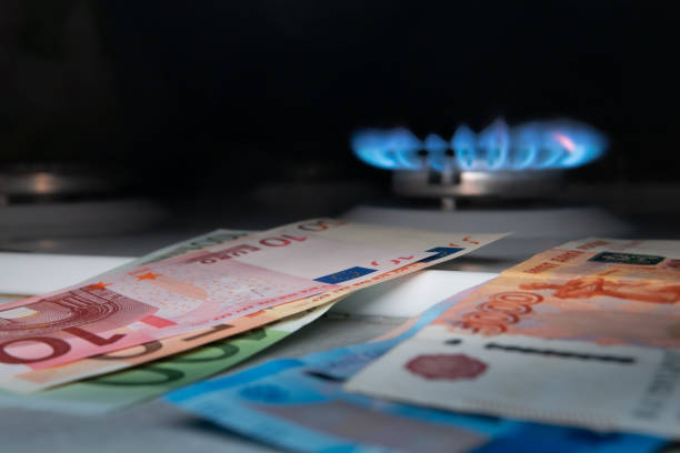 billets en euros sur fond de billets russes et d’un brûleur à gaz. concept de crise du gaz. argent. prix élevés des ressources naturelles. langues de flamme. dette publique. fokus sélectifs - natural gas gas burner flame photos et images de collection