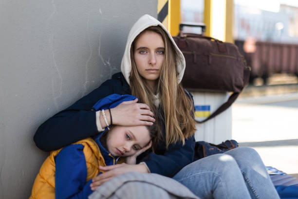 Depressed Ukrainian immigrants sitting and waiting at railway station. Depressed Ukrainian immigrants sitting and waiting at a railway station. eastern europe stock pictures, royalty-free photos & images