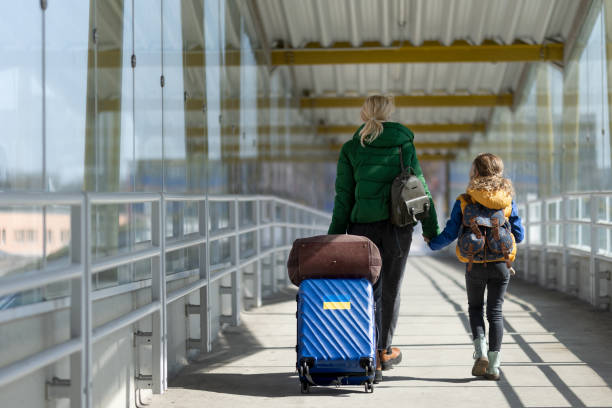 vista posteriore della madre immigrata ucraina con bambino con bagagli che camminano alla stazione ferroviaria, concetto di guerra ucraino. - rear view family isolated child foto e immagini stock