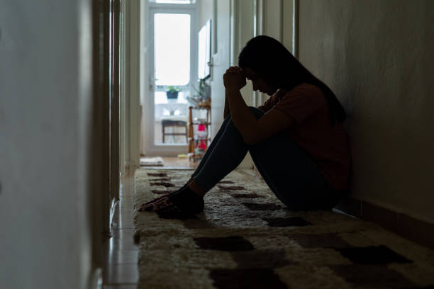 istock Sad woman sitting corridor floor 1393321887